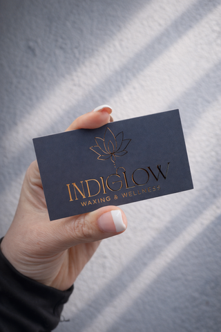 Luxury navy business card with gold foil logo for Indiglow Waxing and Wellness in Southern Oregon