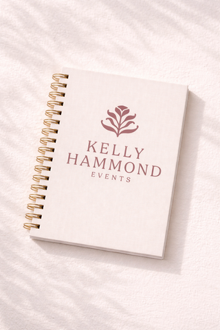 Elegant event planner branding notebook with soft pink logo and gold spiral binding for Kelly Hammond Events