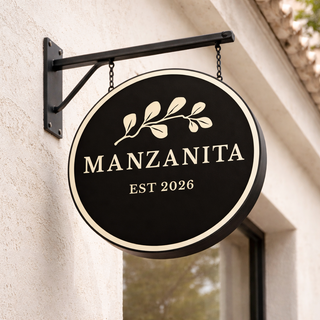 Restaurant logo signage for Manzanita Kitchen and Cocktails featuring circular hanging sign with botanical branding