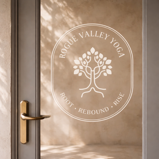 Yoga studio logo design for Rogue Valley Yoga displayed as a frosted glass door decal with custom tree icon and circular brand identity