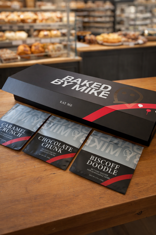 Baked by Mike chocolate packaging on a wooden surface with a bakery background
