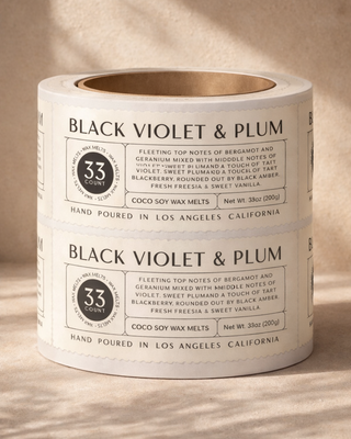 Roll of custom vinyl product labels for Black Violet & Plum wax melts, showing premium peel-and-apply roll labels used for candle and wax melt packaging.